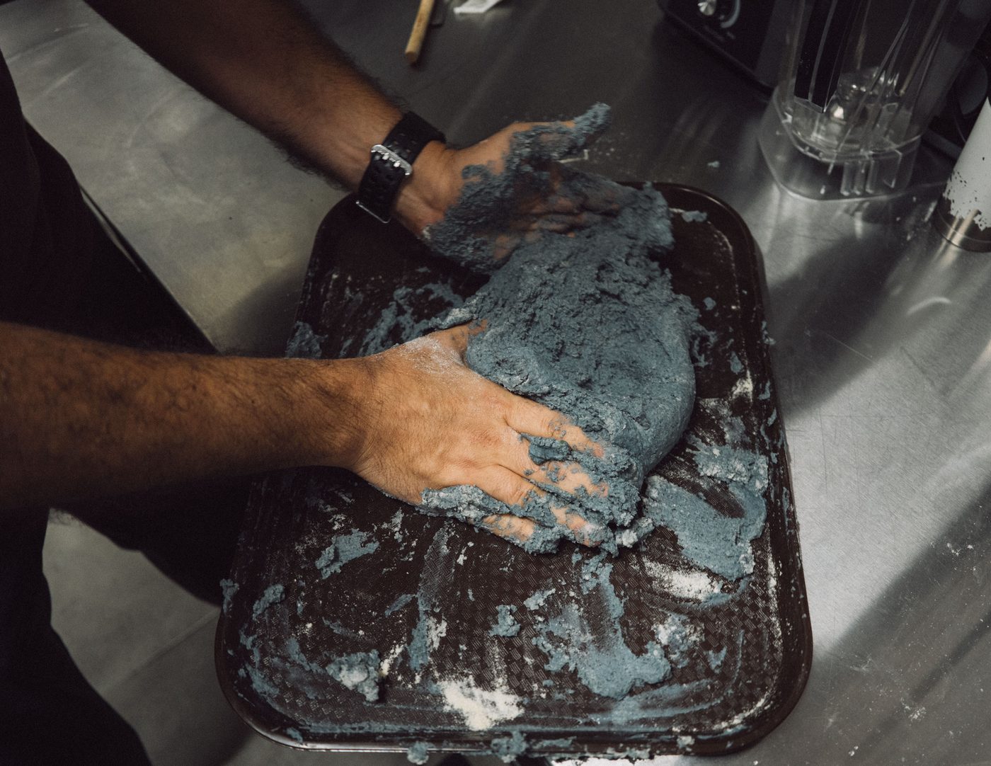 Manos amasando masa de maíz negro nixtamalizado