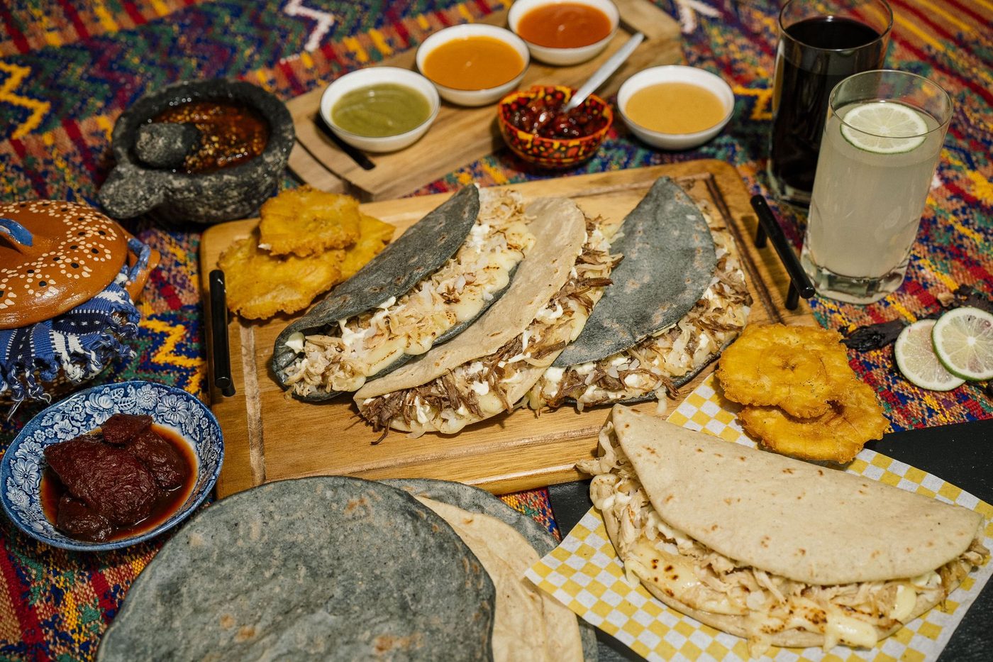 Kesiyos con tostones y salsas de la casa sobre una tabla